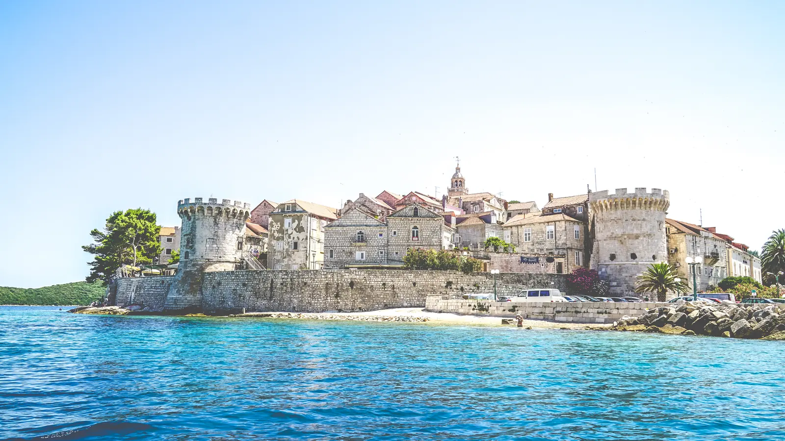 The walled old town of Korčula seen from the sea, with stone towers and red roofs, Croatia