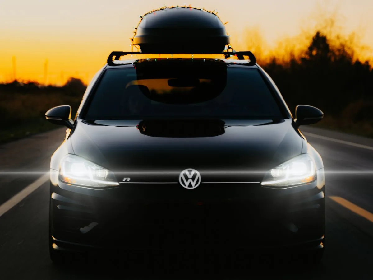 Car with a roof box driving at sunset